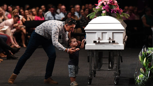 Hannah Clarke's brother Nat holds his son Tyler as he reaches for the coffin.