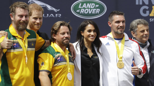 Prince Harry and Meghan, Duchess of Sussex  with medal winners at the Invictus Games driving challenge on Cockatoo Island in Sydney