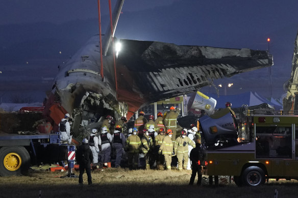 A rescue team carries the body of a passenger from the wreckage.