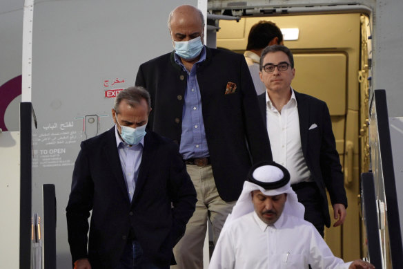 From left, Emad Sharghi, Morad Tahbaz and Siamak Namazi, former prisoners in Iran, walk out of a Qatar Airways flight in Qatar.