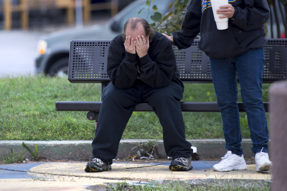 David Thevo of Kansas City, Kansas, is consoled by a friend after two gunmen entered a bar early on Sunday and shot multiple people.  