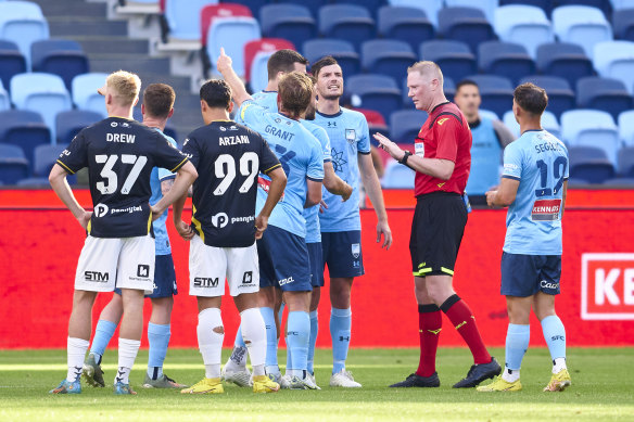 Rhyan Grant of Sydney FC appeals to referee Kurt Ams after a red card was given to teammate James Donachie.