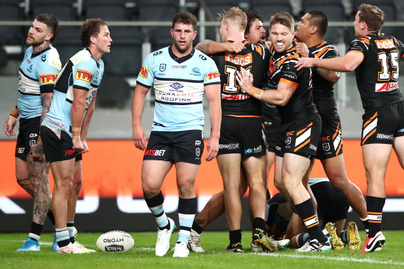 Josh Aloiai of the Wests Tigers celebrates scoring a try.