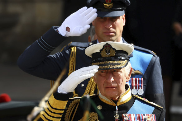 King Charles III and Prince William, the Prince of Wales, salute the Queen.