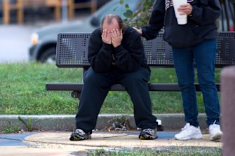 David Thevo of Kansas City, Kansas, is consoled by a friend at nearby Lally Park after two gunmen entered a Kansas City, Kansas, bar early Sunday and shot multiple people, killing several of them.  