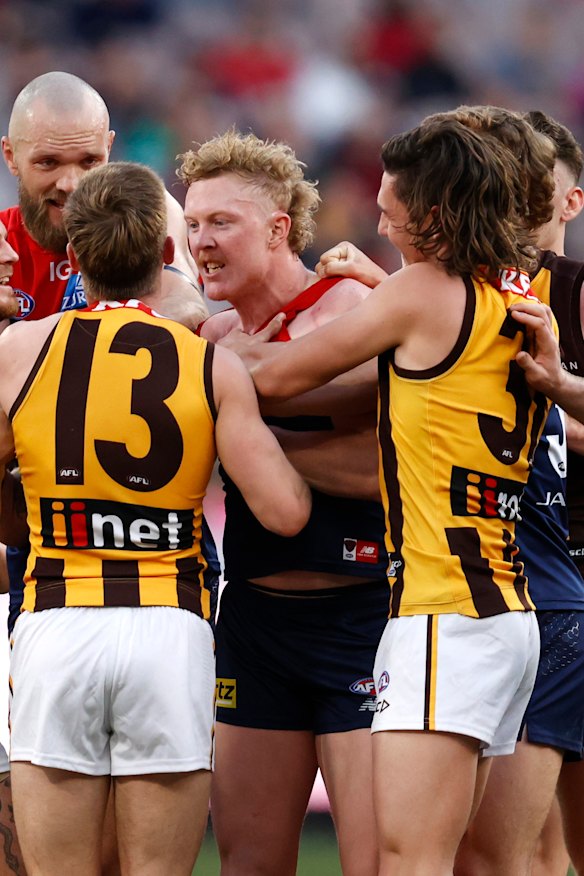 Clayton Oliver wrestles with Dylan Moore.