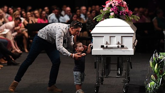 Hannah Clarke's brother Nat holds his son Tyler as he reaches for the coffin during the funeral for Hannah and her three children Aaliyah, Laianah and Trey in Brisbane, Monday, March 9, 2020. Hannah and her children were murdered by their estranged husband and father in a domestic violence incident on February 19. (AAP Image/Dan Peled) NO ARCHIVING
