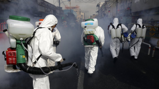 Firefighters disinfect a street in Tehran on Friday.