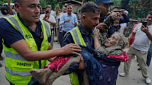 Rescuers carry a victim of flash flooding to safety along the Trishuli River in Nepal’s Nuwakot district.