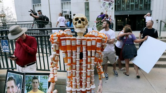 A skeleton made of pill bottles stands with protesters outside a courthouse in Boston in August 2019, where a judge was hearing arguments against opioid maker Purdue Pharma.
