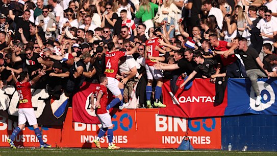Patrick Antelmi celebrates a goal with Sydney United 58 teammates and fans.