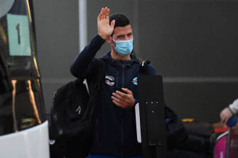 Novak Djokovic waves as he arrives at Adelaide Airport on Thursday. 