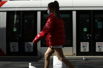 Pedestrians wear face masks to prevent the spread of coronavirus at Town Hall in Sydney's CBD.