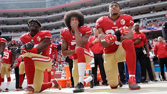 Prominence: Colin Kaepernick (centre) hasn't found a new team, but remains at the forefront of the anthem issue.