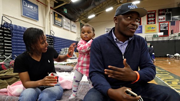 Prince Pombo speaks about his family's journey as migrants from Africa at the Portland Exposition Building. With him is wife Thaiz Neri and daughter Heaven.