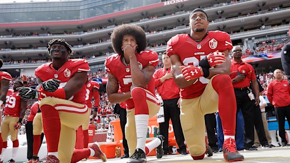 Colin Kaepernick (centre), then the quarterback of the San Francisco 49ers, takes a knee during the national anthem with teammates Eli Harold (left) and Eric Reid at an NFL game in October 2016.