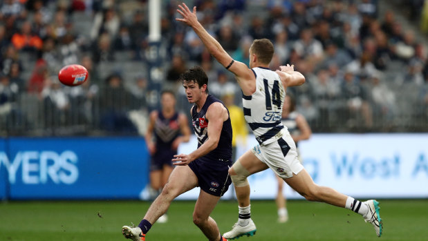 Caught short: Andrew Brayshaw of the Dockers kicks past Joel Selwood of the Cats.