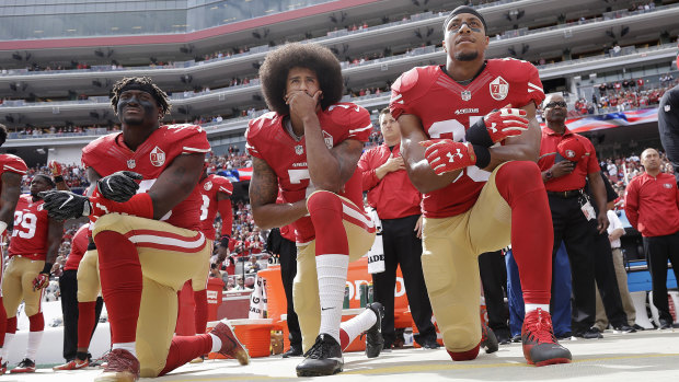 Prominence: Colin Kaepernick (centre) hasn't found a new team, but remains at the forefront of the anthem issue.