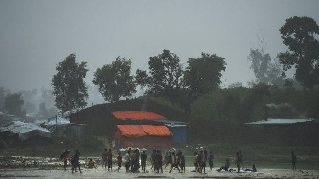 Rohingya children play in a downpour at the world's largest refugee camp at Cox's Bazar last year.