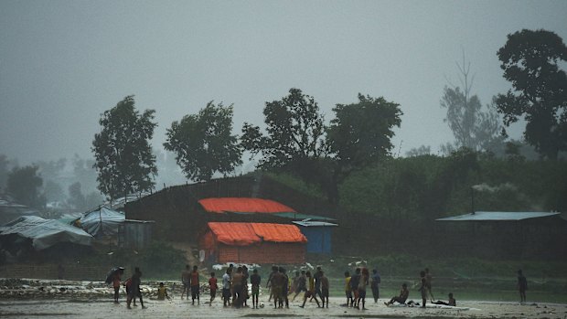 Rohingya children play in a downpour at the world's largest refugee camp at Cox's Bazar last year.