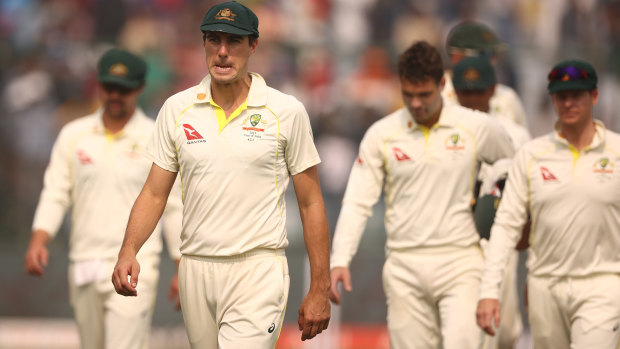 Pat Cummins leads the dejected Australians from the field in Delhi.