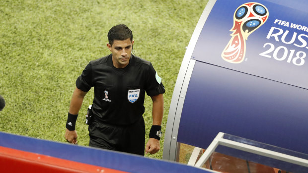 Tick of approval: Referee Enrique Caceres goes to watch the VAR during Portugal's match against Iran.