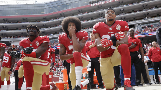 Colin Kaepernick (centre) kneeling in protest. 