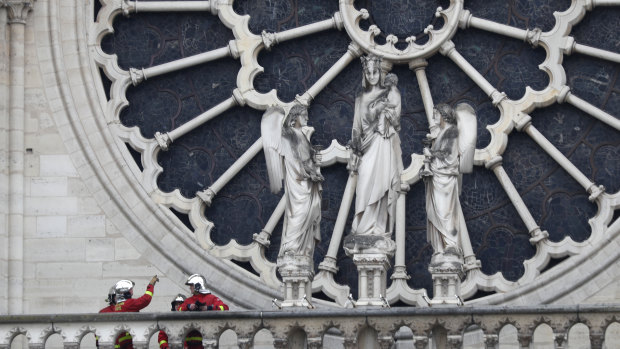 Firefighters assess Notre-Dame's famous rose window after the fire.