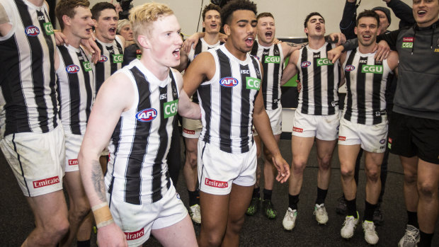 John Noble celebrates with teammates after Collingwood's round 17 win over West Coast.