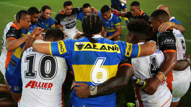 Coming together: Players from the Tigers and Eels in a post-game prayer circle.