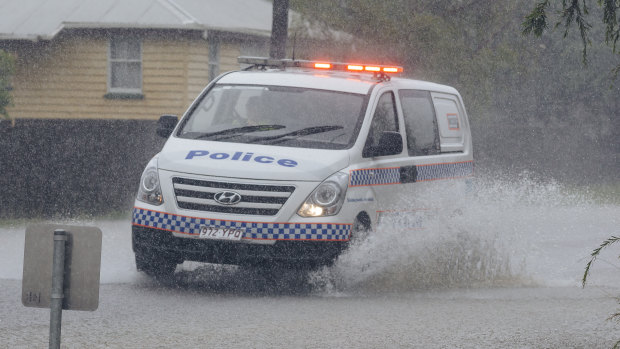 A police car drives through floodwater in south Townsville.