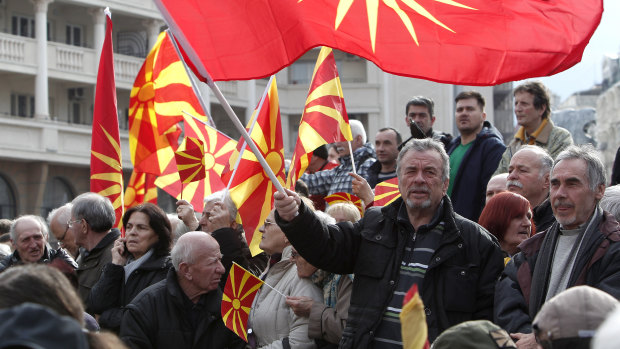 People wave the old and present national flag in a protest against the change of the country's constitutional name, in downtown Skopje, in November 2018.