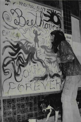 Lindsay Blue, of Glebe, finishes one of the displays in a shop window in Nimbin for the Aquarius Festival