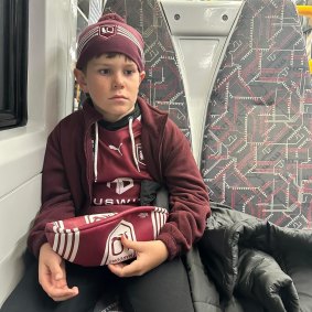 A devastated 11-year-old Carter McPherson on the train home from Suncorp Stadium.