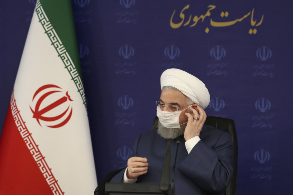 President Hassan Rouhani adjusts his face mask in Tehran during a meeting on the nation's fight against COVID-19.