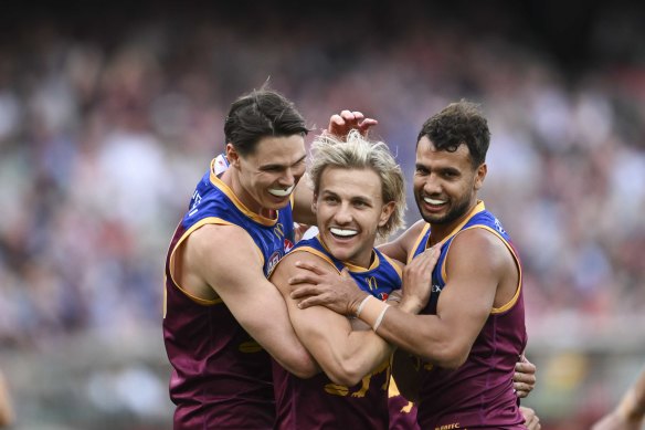 Brisbane Lion Kai Lohmann (centre), who kicked four goals in the AFL grand final against Sydney, is congratulated by teammates Eric Hipwood and Callum Ah Chee.