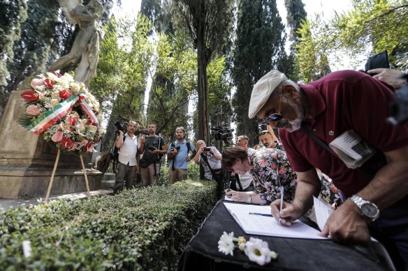 People pay homage at the grave of  Andrea Camilleri in Rome on Thursday.