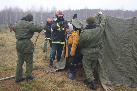 Belarusian servicemen set up a tent for migrants gathering at the Belarus-Poland border near Grodno, Belarus.