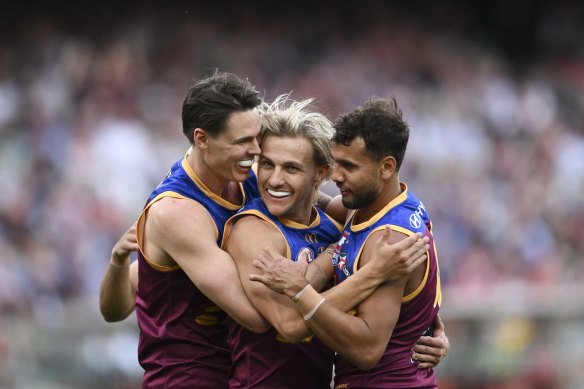 Brisbane’s Eric Hipwood, Kai Lohmann and Callum Ah Chee embrace during the AFL grand final.