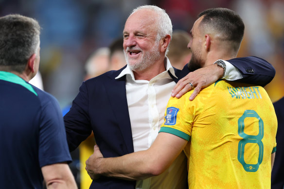 Socceroos coach Graham Arnold celebrates with Bailey Wright after the Denmark win.