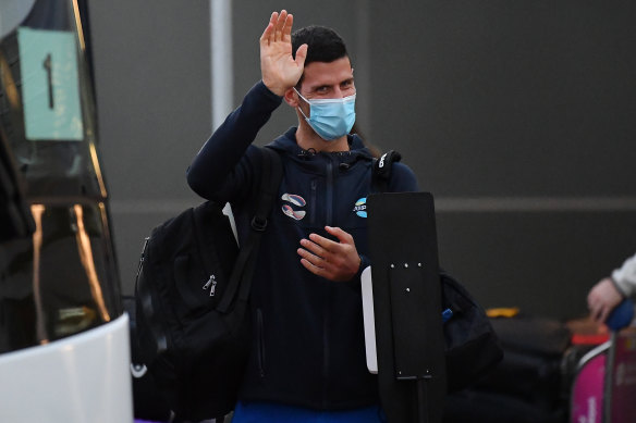 Novak Djokovic waves as he arrives at Adelaide Airport on Thursday. 