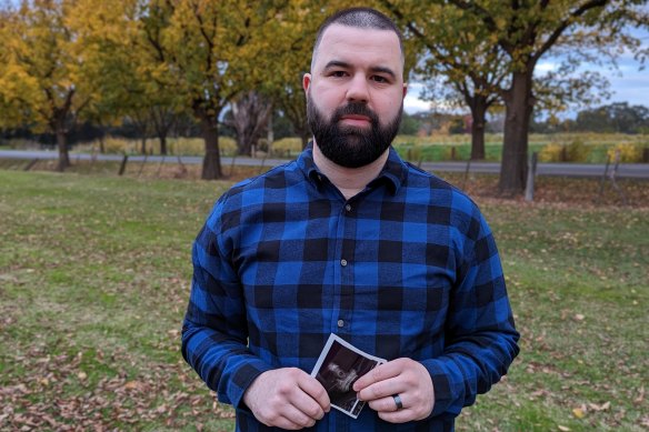 Matt Romania holds an ultrasound image of his first child.