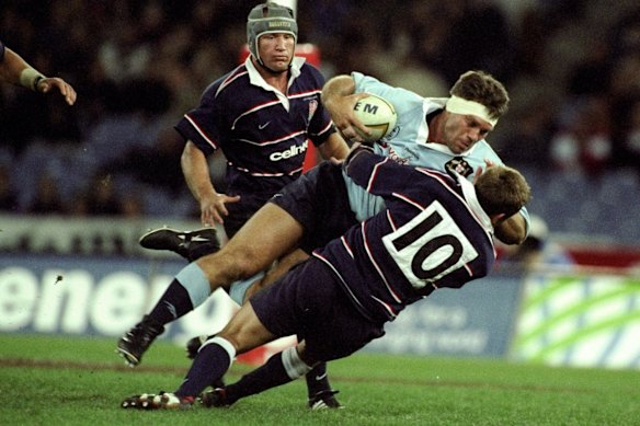  Tiaan Strauss of Australia is tackled by Jonny Wilkinson of England during the Centennary Test Match in 1999 in Sydney