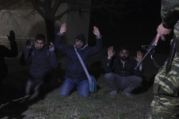 Greek soldiers arrest migrants in the village of Kastanies, near the Greek-Turkish border on Friday. Thousands of refugees and other asylum-seekers have tried to enter Greece from the land and sea in the week since Turkey said it would no longer block their passage.