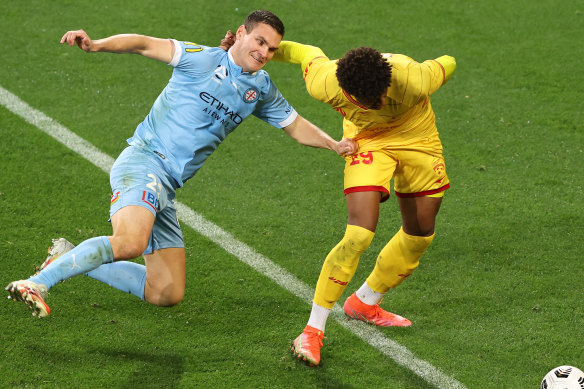 Curtis Good of Melbourne City and Kusini Yengi of Adelaide United compete for the ball.