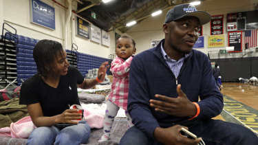 Prince Pombo speaks about his family's journey as migrants from Africa at the Portland Exposition Building. With him is wife Thaiz Neri and daughter Heaven.