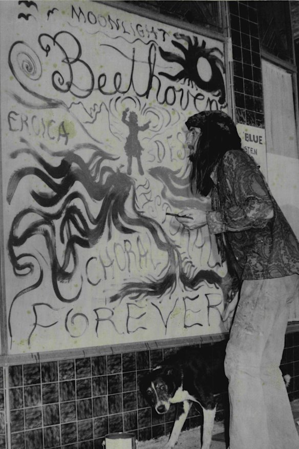 Lindsay Blue, of Glebe, finishes one of the displays in a shop window in Nimbin for the Aquarius Festival