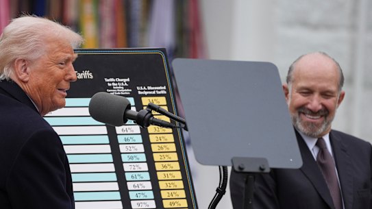 Donald Trump lovingly cuddled a big poster detailing the tariff vengeance he was about to unleash.