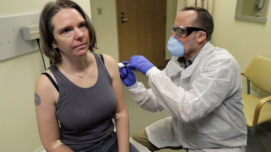 A pharmacist gives Jennifer Haller, left, the first shot in the first-stage safety study clinical trial of a potential vaccine for COVID-19, at the Kaiser Permanente Washington Health Research Institute in Seattle. 