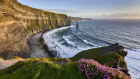 The setting sun bathes the Cliffs of Moher, which are the gateway to the Wild Atlantic Way. 